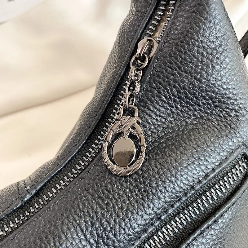 Bolsa Milena em couro legítimo, estilo baguete. Compacta, elegante e versátil, com zíper, forro em algodão e alça para usar no ombro ou na mão.