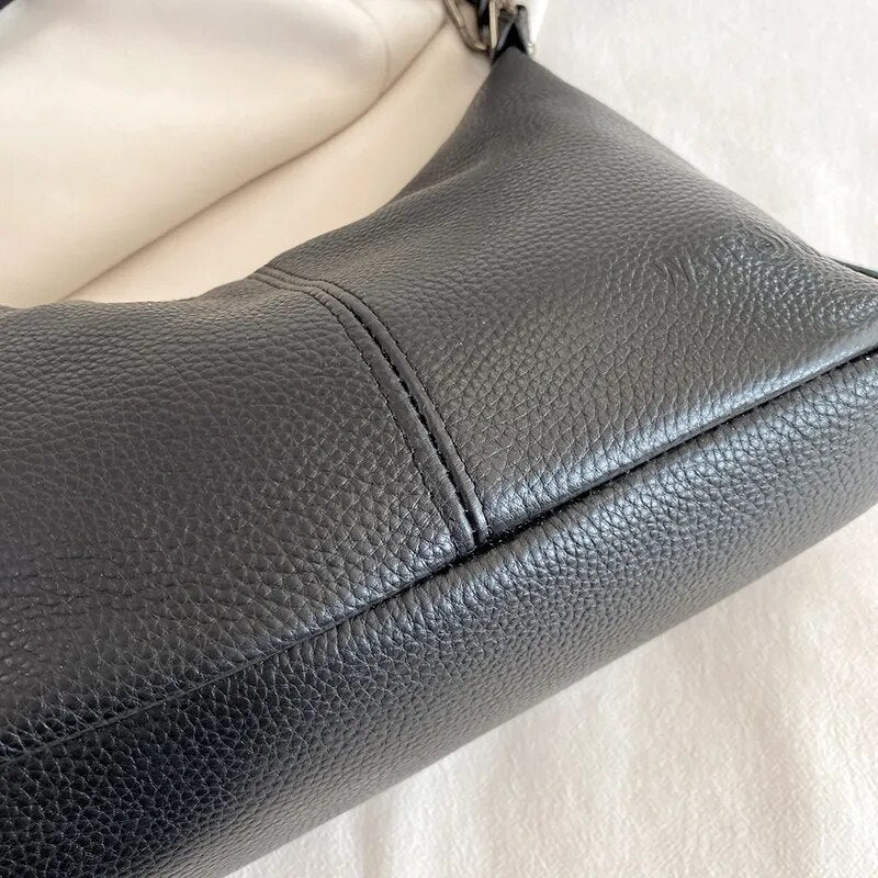 Bolsa Milena em couro legítimo, estilo baguete. Compacta, elegante e versátil, com zíper, forro em algodão e alça para usar no ombro ou na mão.