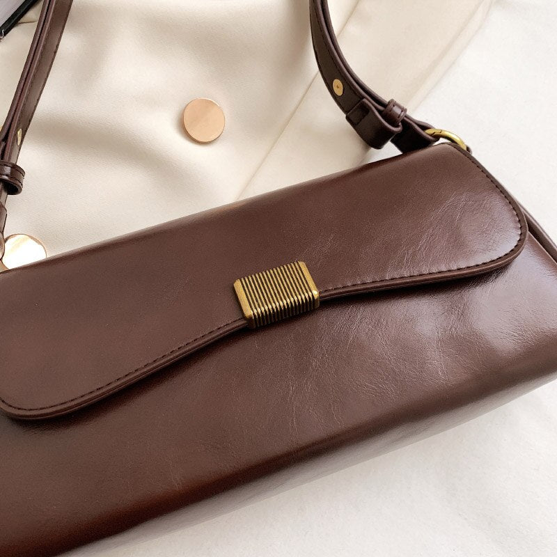 Bolsa Renata em couro legítimo, estilo baguete. Sofisticada e espaçosa, com zíper e botão magnético, perfeita para looks elegantes e versáteis do dia a dia.