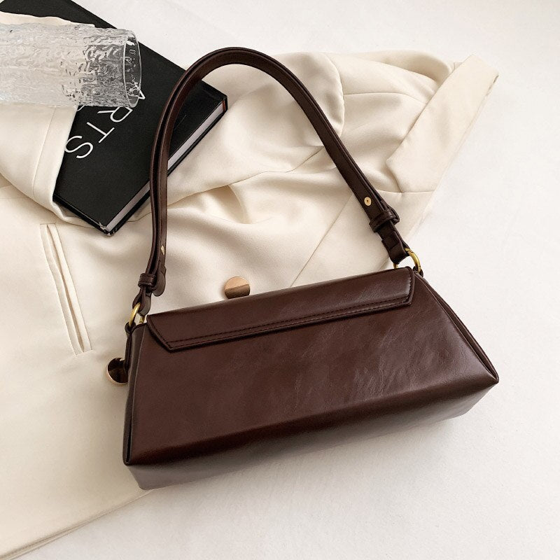 Bolsa Renata em couro legítimo, estilo baguete. Sofisticada e espaçosa, com zíper e botão magnético, perfeita para looks elegantes e versáteis do dia a dia.