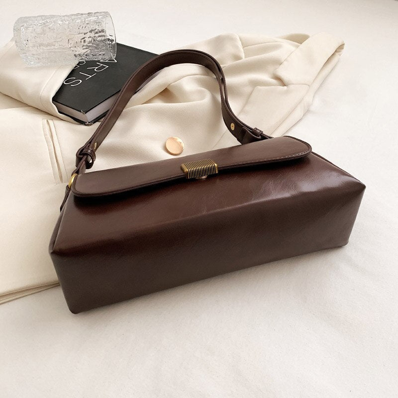 Bolsa Renata em couro legítimo, estilo baguete. Sofisticada e espaçosa, com zíper e botão magnético, perfeita para looks elegantes e versáteis do dia a dia.