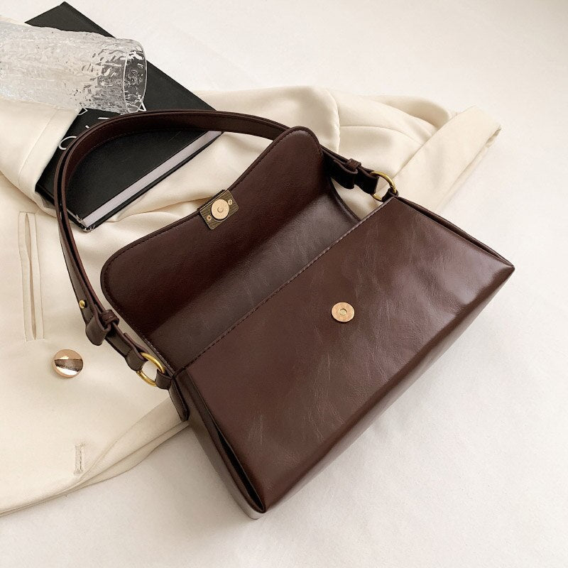 Bolsa Renata em couro legítimo, estilo baguete. Sofisticada e espaçosa, com zíper e botão magnético, perfeita para looks elegantes e versáteis do dia a dia.