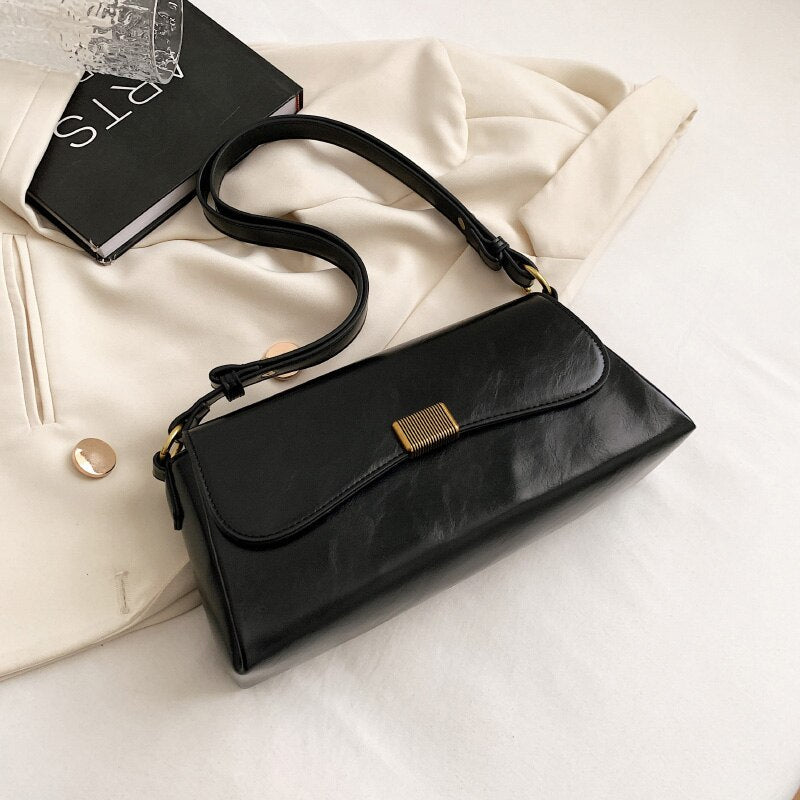 Bolsa Renata em couro legítimo, estilo baguete. Sofisticada e espaçosa, com zíper e botão magnético, perfeita para looks elegantes e versáteis do dia a dia.