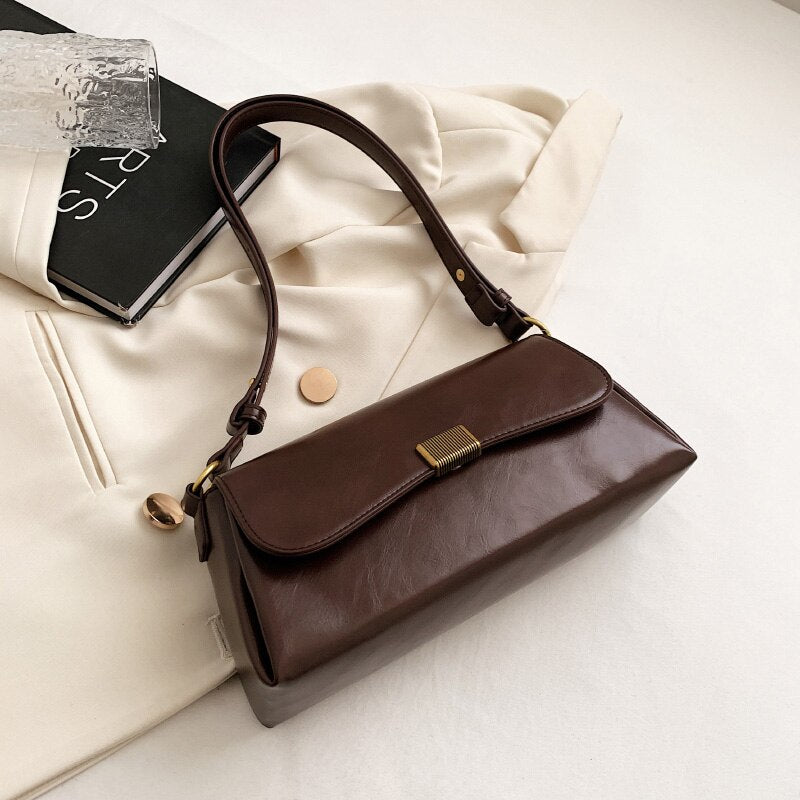 Bolsa Renata em couro legítimo, estilo baguete. Sofisticada e espaçosa, com zíper e botão magnético, perfeita para looks elegantes e versáteis do dia a dia.