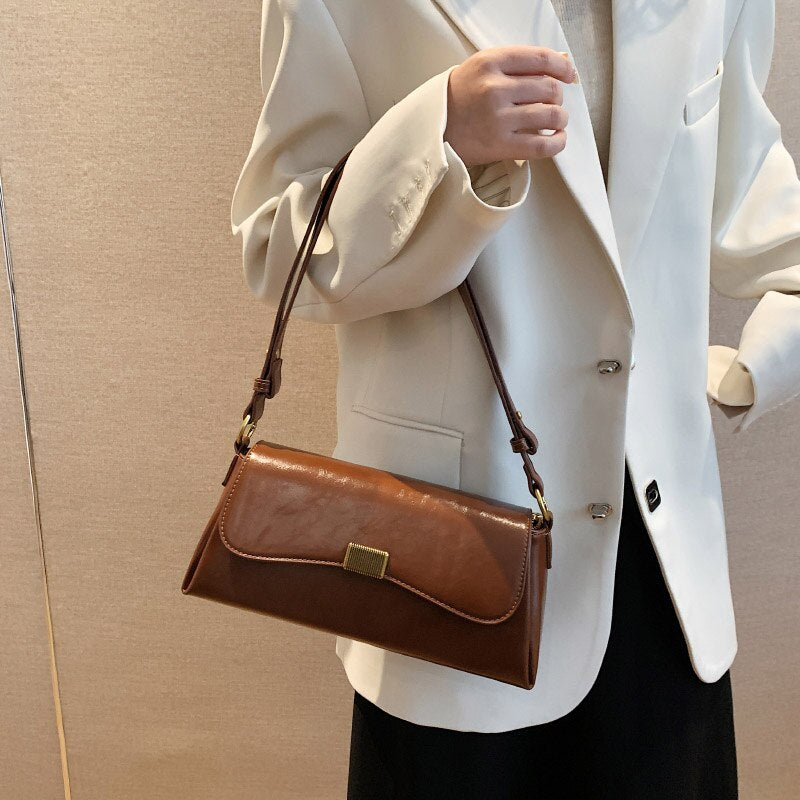 Bolsa Renata em couro legítimo, estilo baguete. Sofisticada e espaçosa, com zíper e botão magnético, perfeita para looks elegantes e versáteis do dia a dia.