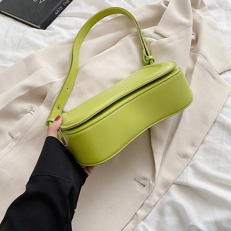 Bolsa Emily estilo baguete com design ondulado. Compacta, elegante e versátil, em material sintético com botão magnético e espaço ideal para o dia a dia.