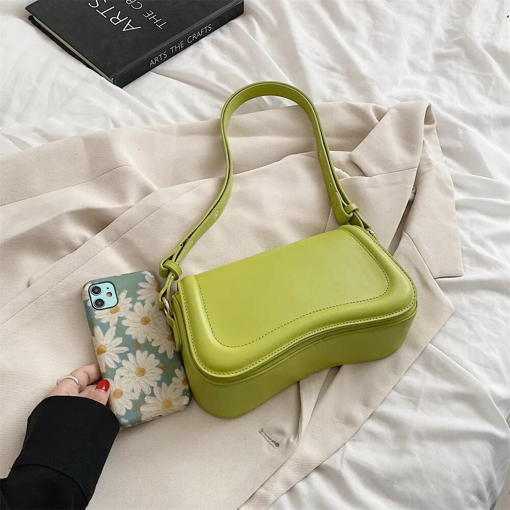Bolsa Emily estilo baguete com design ondulado. Compacta, elegante e versátil, em material sintético com botão magnético e espaço ideal para o dia a dia.