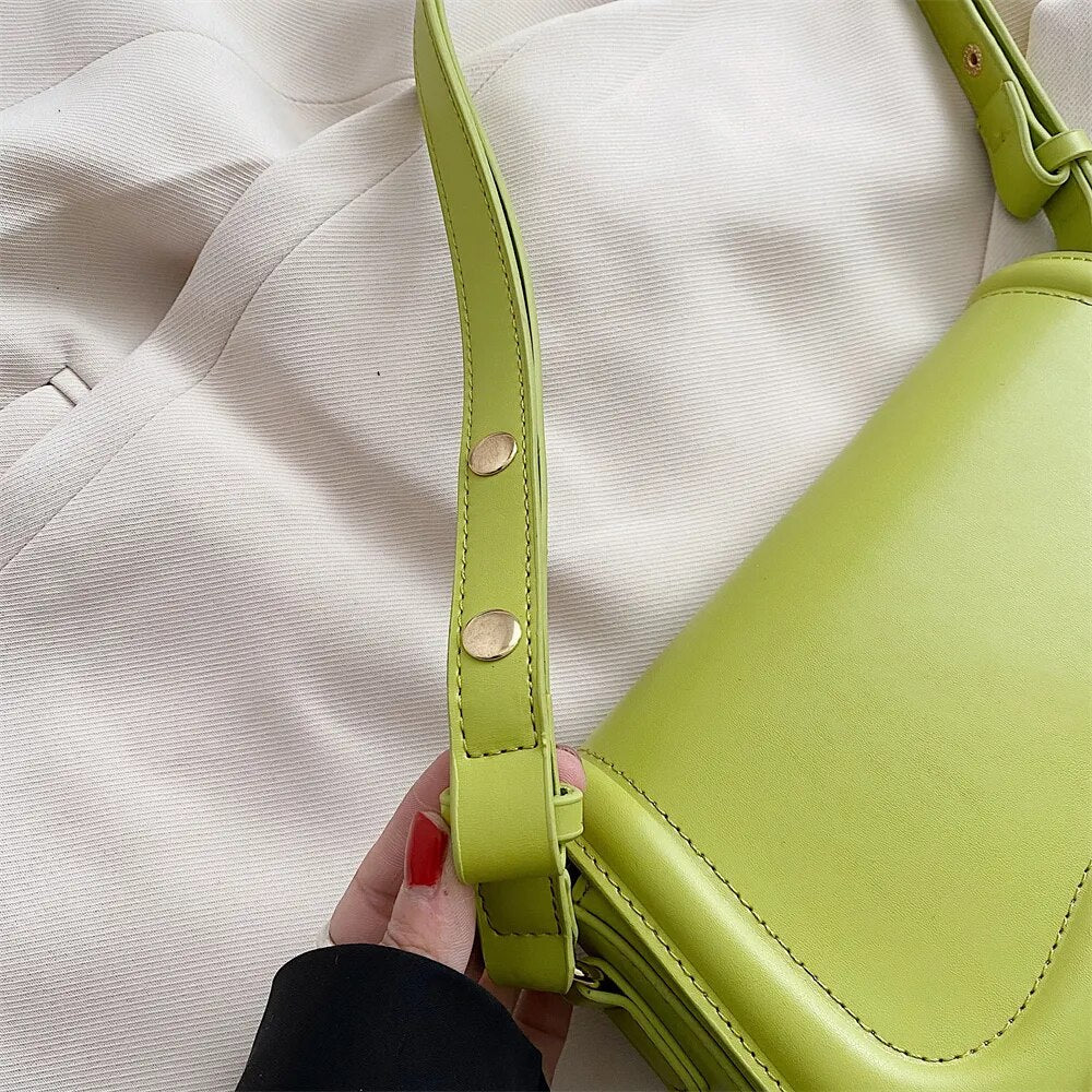Bolsa Emily estilo baguete com design ondulado. Compacta, elegante e versátil, em material sintético com botão magnético e espaço ideal para o dia a dia.