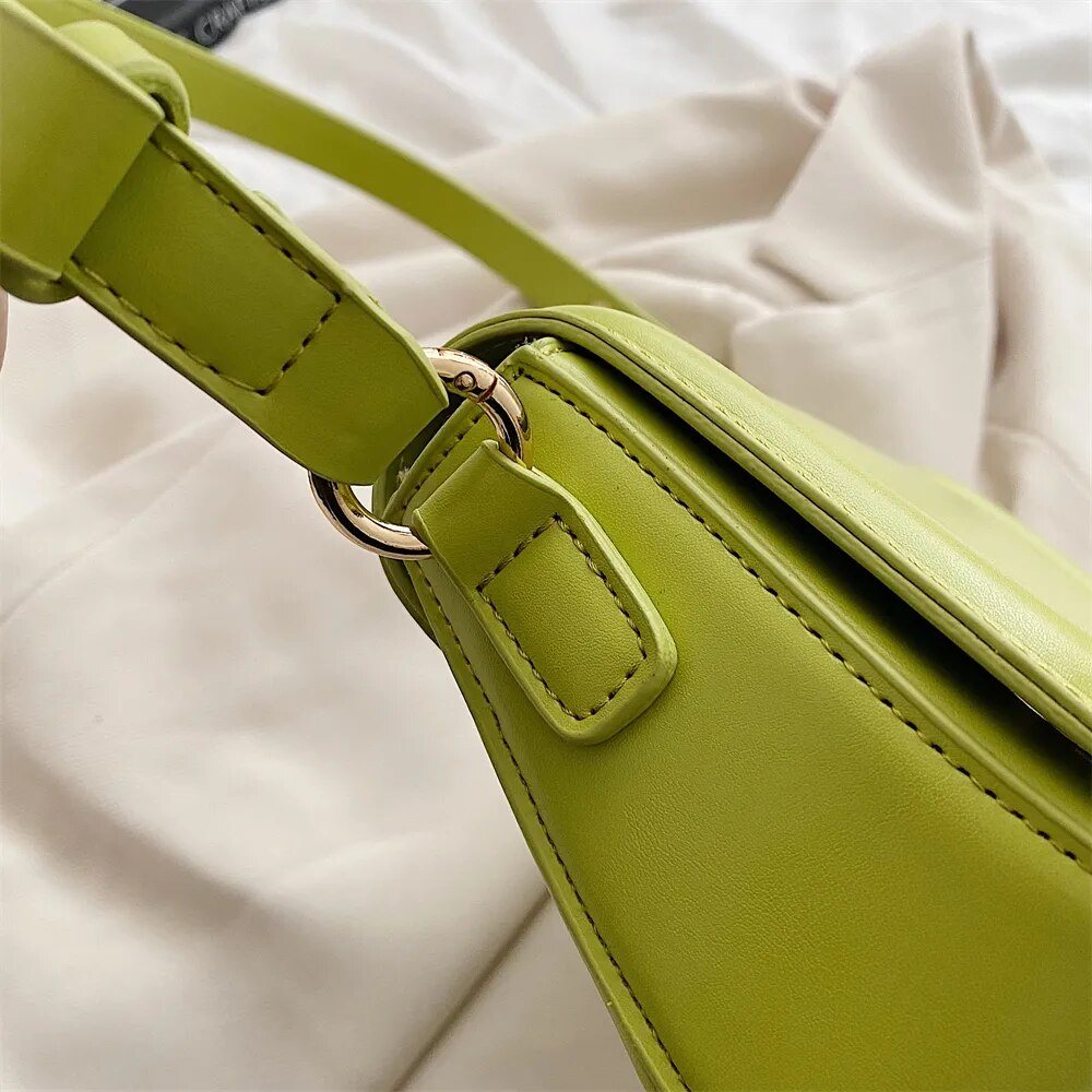 Bolsa Emily estilo baguete com design ondulado. Compacta, elegante e versátil, em material sintético com botão magnético e espaço ideal para o dia a dia.