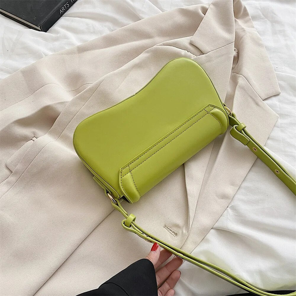Bolsa Emily estilo baguete com design ondulado. Compacta, elegante e versátil, em material sintético com botão magnético e espaço ideal para o dia a dia.