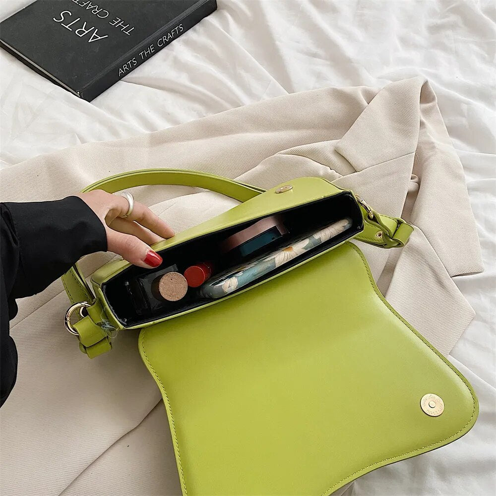 Bolsa Emily estilo baguete com design ondulado. Compacta, elegante e versátil, em material sintético com botão magnético e espaço ideal para o dia a dia.