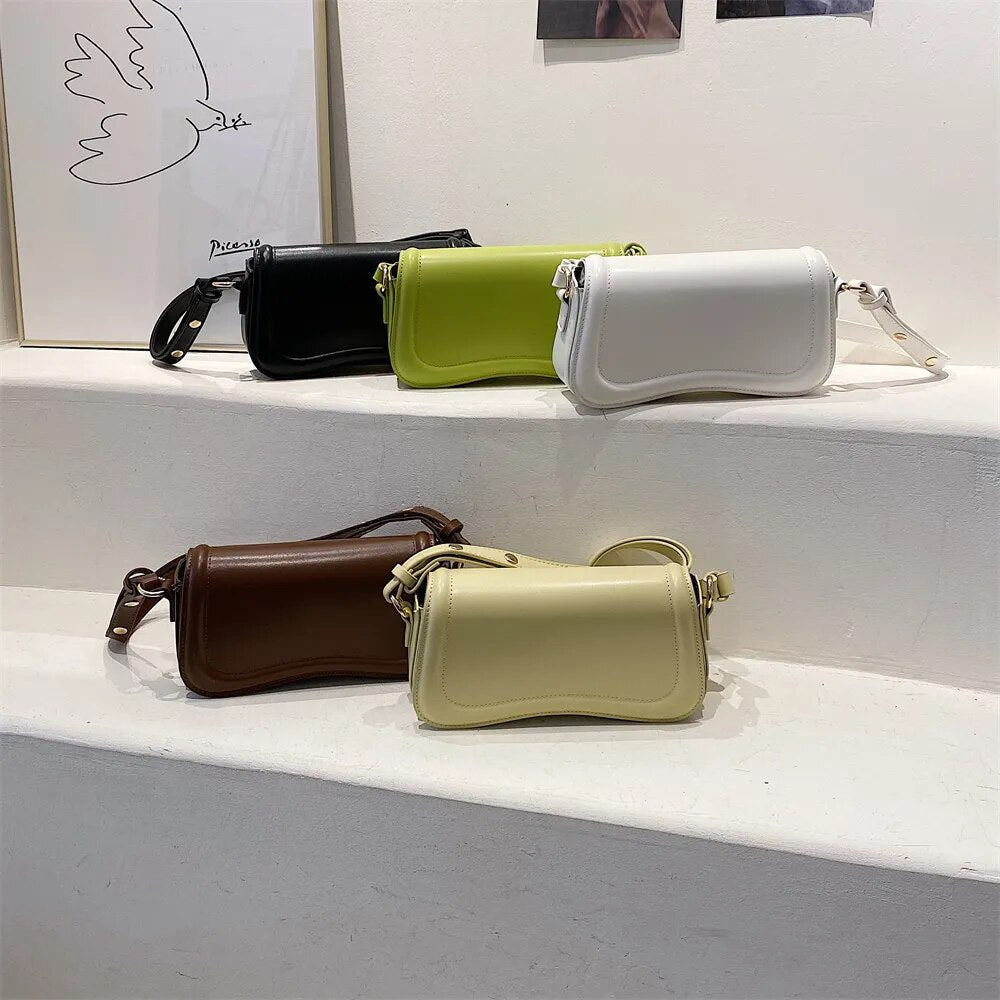 Bolsa Emily estilo baguete com design ondulado. Compacta, elegante e versátil, em material sintético com botão magnético e espaço ideal para o dia a dia.