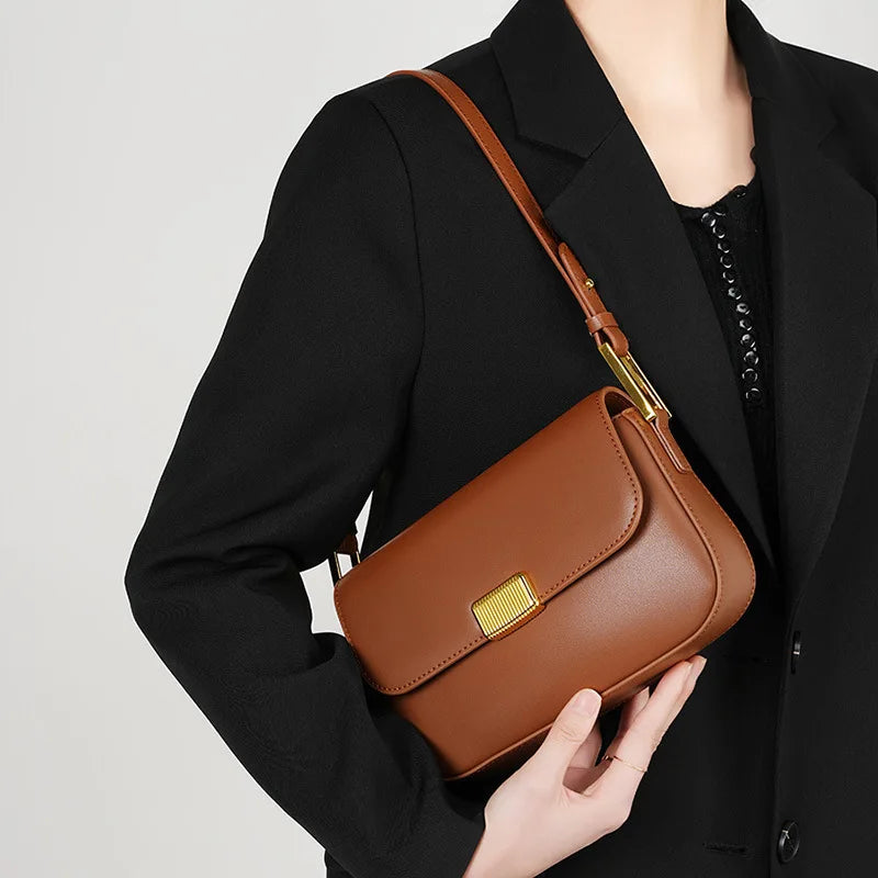 Bolsa Jack em couro legítimo, compacta e moderna. Modelo box bag com botão de encaixe e bolsos internos, une praticidade, estilo e organização no dia a dia.