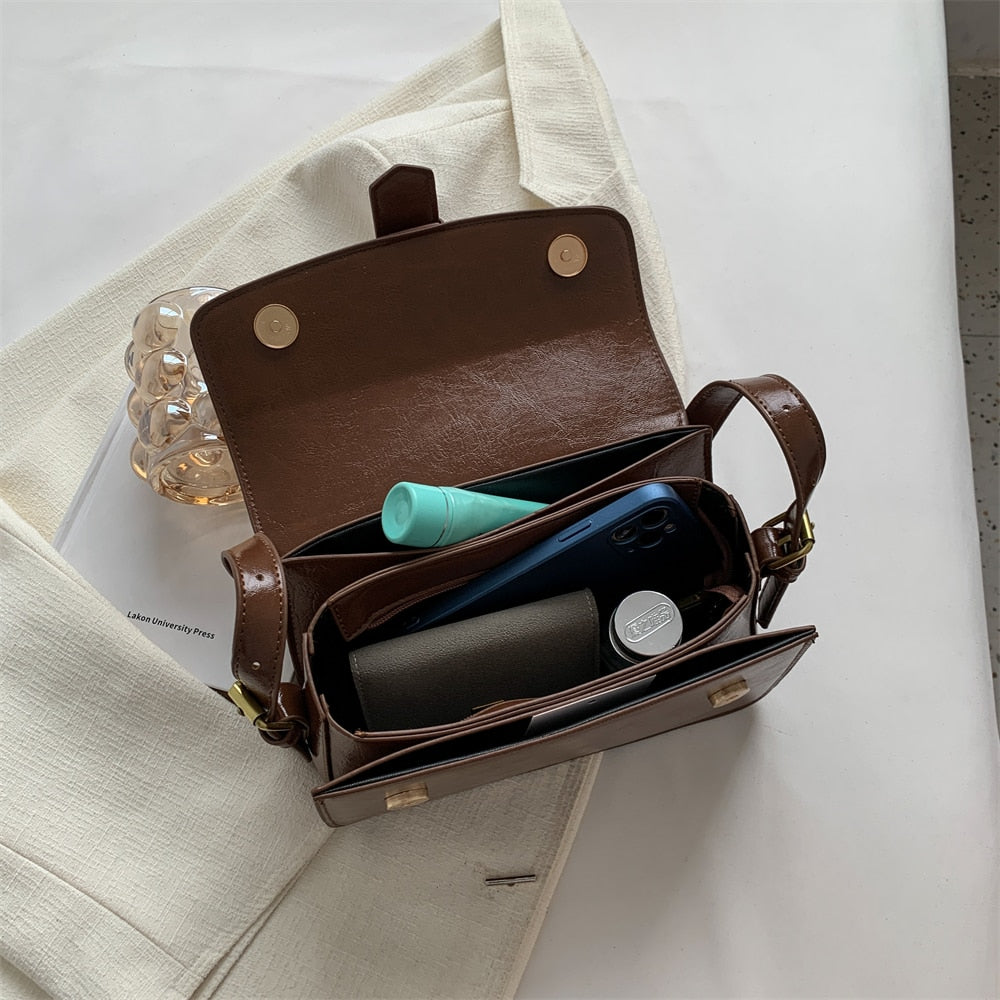 Bolsa Mary estilo baguete, feita em material sintético premium. Compacta, elegante e prática, com zíper, fivela decorativa e espaço para itens essenciais.