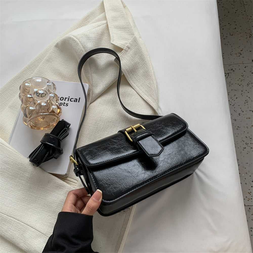 Bolsa Mary estilo baguete, feita em material sintético premium. Compacta, elegante e prática, com zíper, fivela decorativa e espaço para itens essenciais.