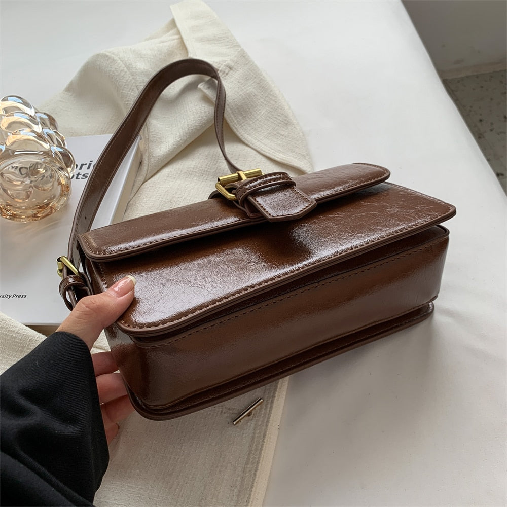 Bolsa Mary estilo baguete, feita em material sintético premium. Compacta, elegante e prática, com zíper, fivela decorativa e espaço para itens essenciais.