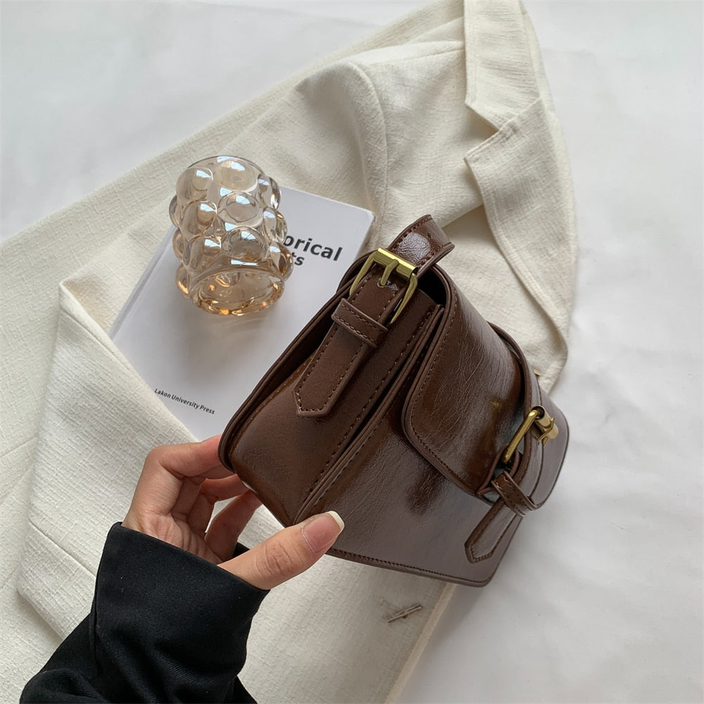 Bolsa Mary estilo baguete, feita em material sintético premium. Compacta, elegante e prática, com zíper, fivela decorativa e espaço para itens essenciais.