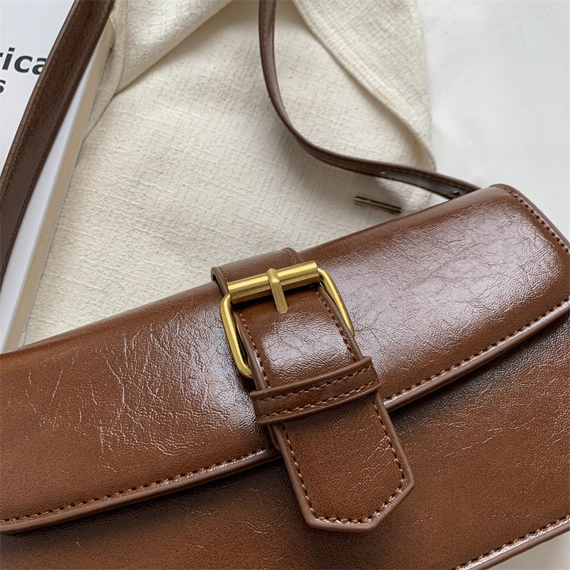 Bolsa Mary estilo baguete, feita em material sintético premium. Compacta, elegante e prática, com zíper, fivela decorativa e espaço para itens essenciais.