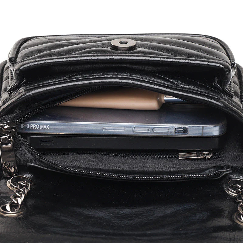 Bolsa Patrícia em couro legítimo, compacta, elegante e durável. Design minimalista com alça ajustável e interior espaçoso para itens essenciais do dia a dia.