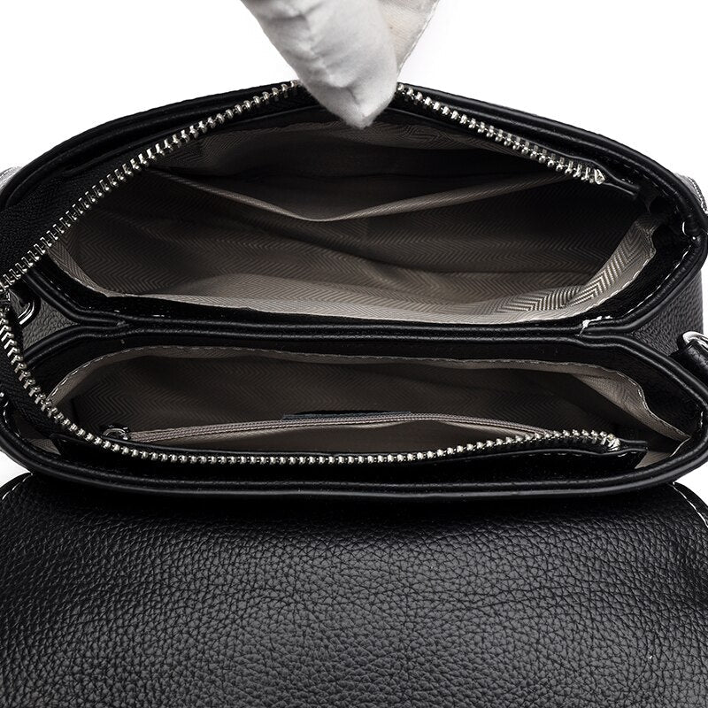 Bolsa Laura em couro legítimo, compacta, elegante e versátil. Com alça ajustável, zíper, botão magnético e divisórias para praticidade no dia a dia.