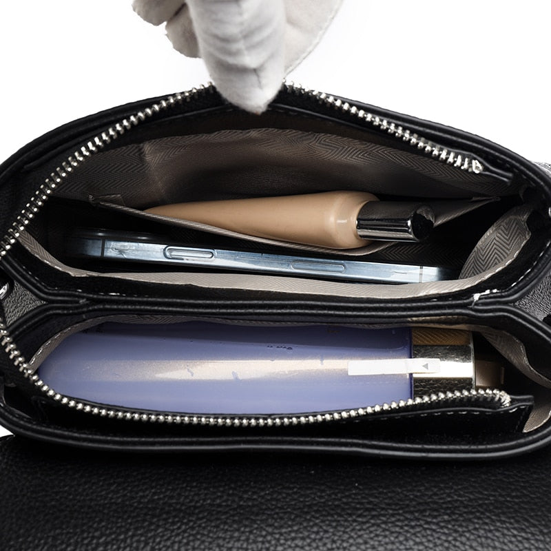 Bolsa Laura em couro legítimo, compacta, elegante e versátil. Com alça ajustável, zíper, botão magnético e divisórias para praticidade no dia a dia.