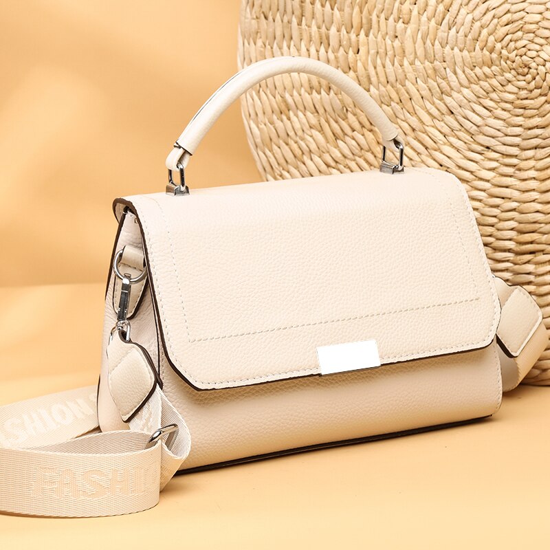 Bolsa Laura em couro legítimo, compacta, elegante e versátil. Com alça ajustável, zíper, botão magnético e divisórias para praticidade no dia a dia.