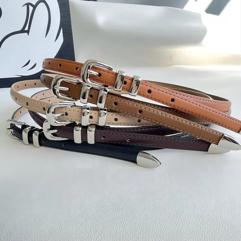 Cinto Mila em couro legítimo, fino e elegante. Design minimalista com fivela prateada em alloy, ideal para looks casuais ou formais com toque sofisticado.