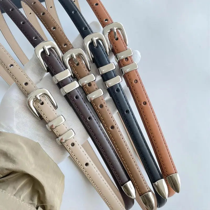 Cinto Mila em couro legítimo, fino e elegante. Design minimalista com fivela prateada em alloy, ideal para looks casuais ou formais com toque sofisticado.