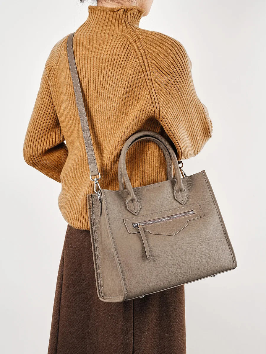 Bolsa Olívia em couro legítimo, tote grande e elegante. Espaçosa, com divisórias, fecho duplo e alças para usar na mão ou no modelo transversal.