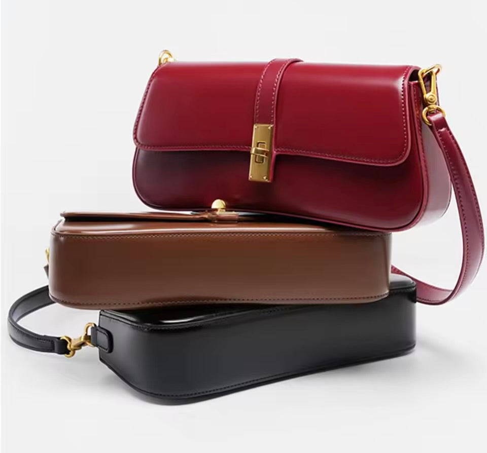 Bolsa Ana em couro legítimo, estilo baguette. Compacta, elegante e resistente, com divisórias internas que garantem praticidade e organização no dia a dia.