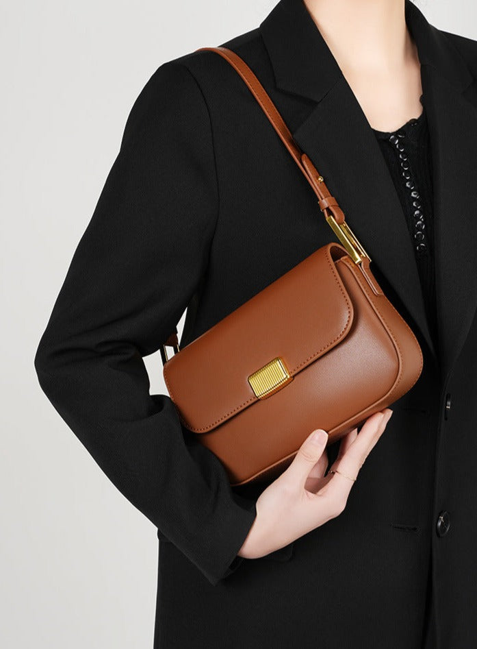 Bolsa Jack em couro legítimo, compacta e moderna. Modelo box bag com botão de encaixe e bolsos internos, une praticidade, estilo e organização no dia a dia.