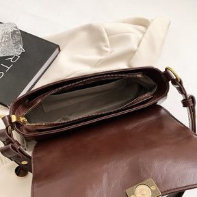 Bolsa Renata em couro legítimo, estilo baguete. Sofisticada e espaçosa, com zíper e botão magnético, perfeita para looks elegantes e versáteis do dia a dia.