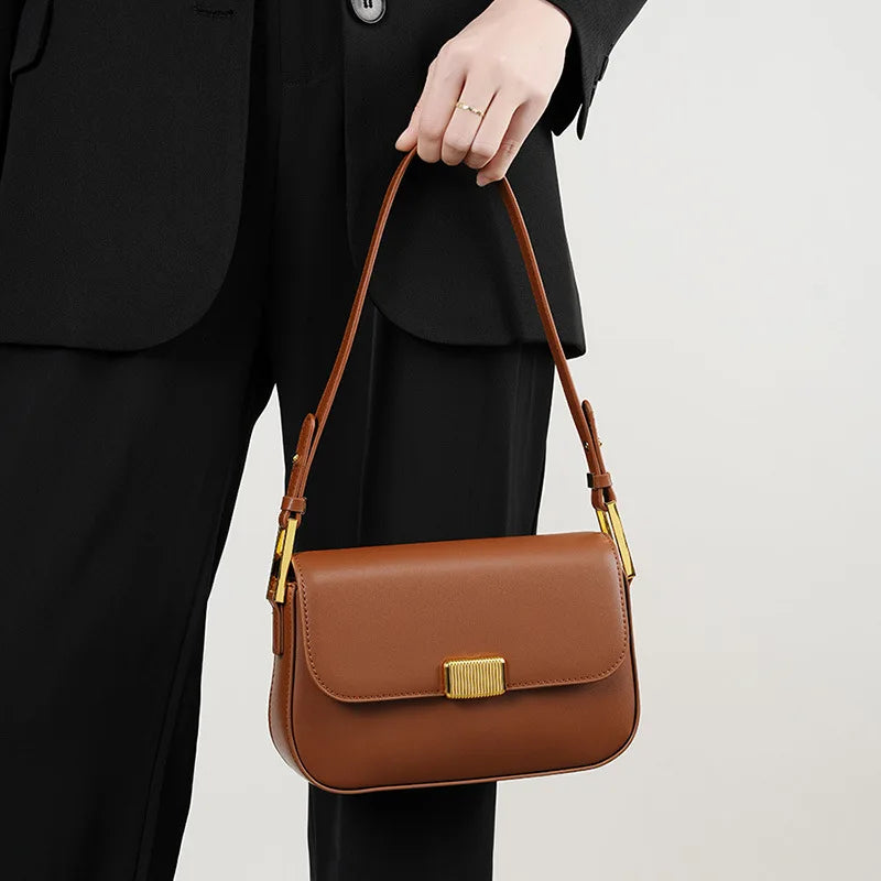 Bolsa Jack em couro legítimo, compacta e moderna. Modelo box bag com botão de encaixe e bolsos internos, une praticidade, estilo e organização no dia a dia.
