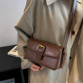 Bolsa Mary estilo baguete, feita em material sintético premium. Compacta, elegante e prática, com zíper, fivela decorativa e espaço para itens essenciais.