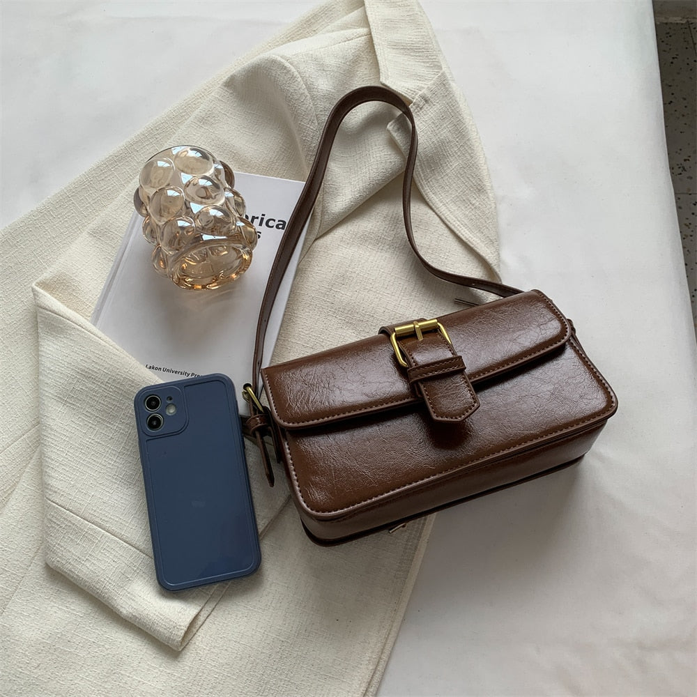 Bolsa Mary estilo baguete, feita em material sintético premium. Compacta, elegante e prática, com zíper, fivela decorativa e espaço para itens essenciais.