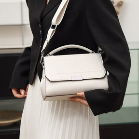 Bolsa Laura em couro legítimo, compacta, elegante e versátil. Com alça ajustável, zíper, botão magnético e divisórias para praticidade no dia a dia.