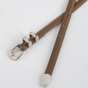 Cinto Mila em couro legítimo, fino e elegante. Design minimalista com fivela prateada em alloy, ideal para looks casuais ou formais com toque sofisticado.