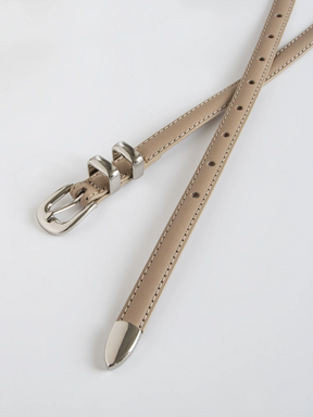 Cinto Mila em couro legítimo, fino e elegante. Design minimalista com fivela prateada em alloy, ideal para looks casuais ou formais com toque sofisticado.