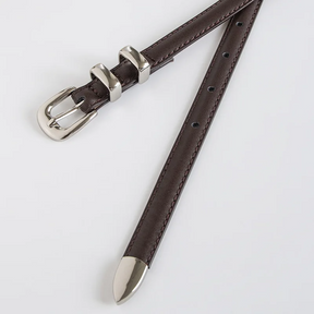 Cinto Mila em couro legítimo, fino e elegante. Design minimalista com fivela prateada em alloy, ideal para looks casuais ou formais com toque sofisticado.