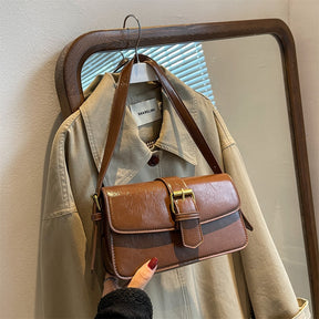 Bolsa Mary estilo baguete, feita em material sintético premium. Compacta, elegante e prática, com zíper, fivela decorativa e espaço para itens essenciais.